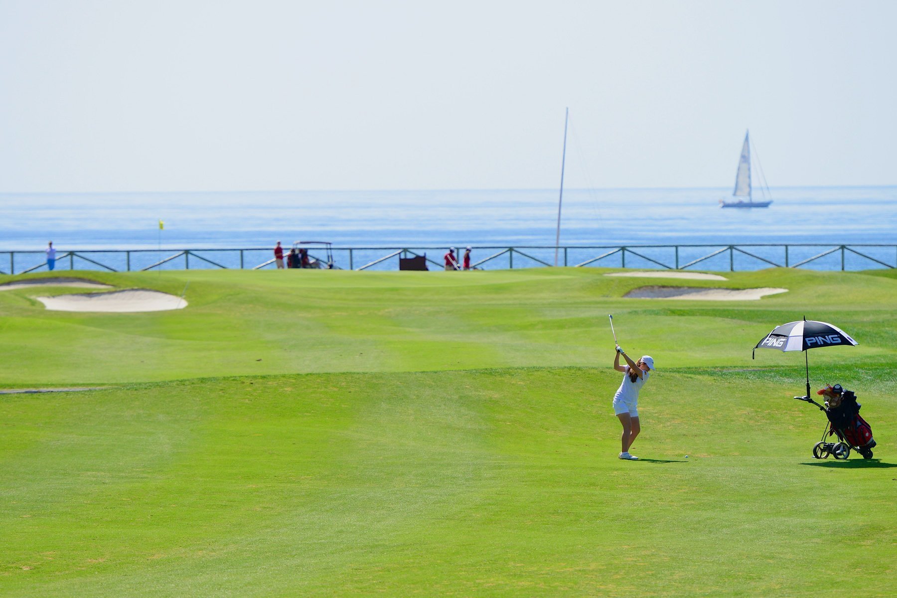 Golf course with green fairways, mature trees, and surrounding residential views