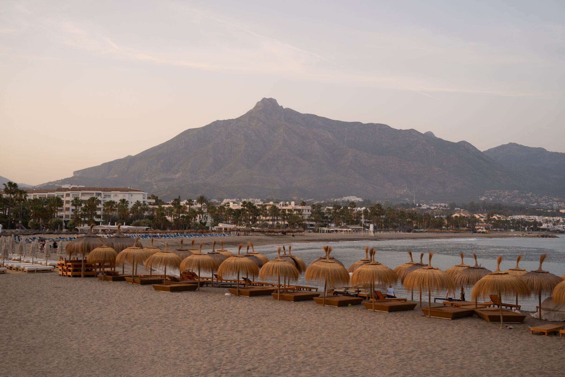 Beach in Puerto Banús with sunbeds, Mediterranean coastline, and La Concha mountain in Marbella