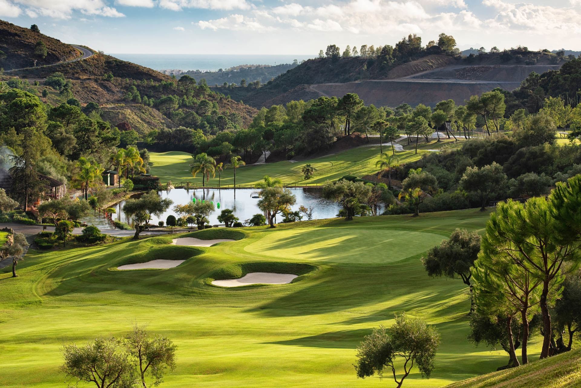 Marbella Club Golf Resort in Benahavís with green fairways, lake, surrounding hills, and Mediterranean views